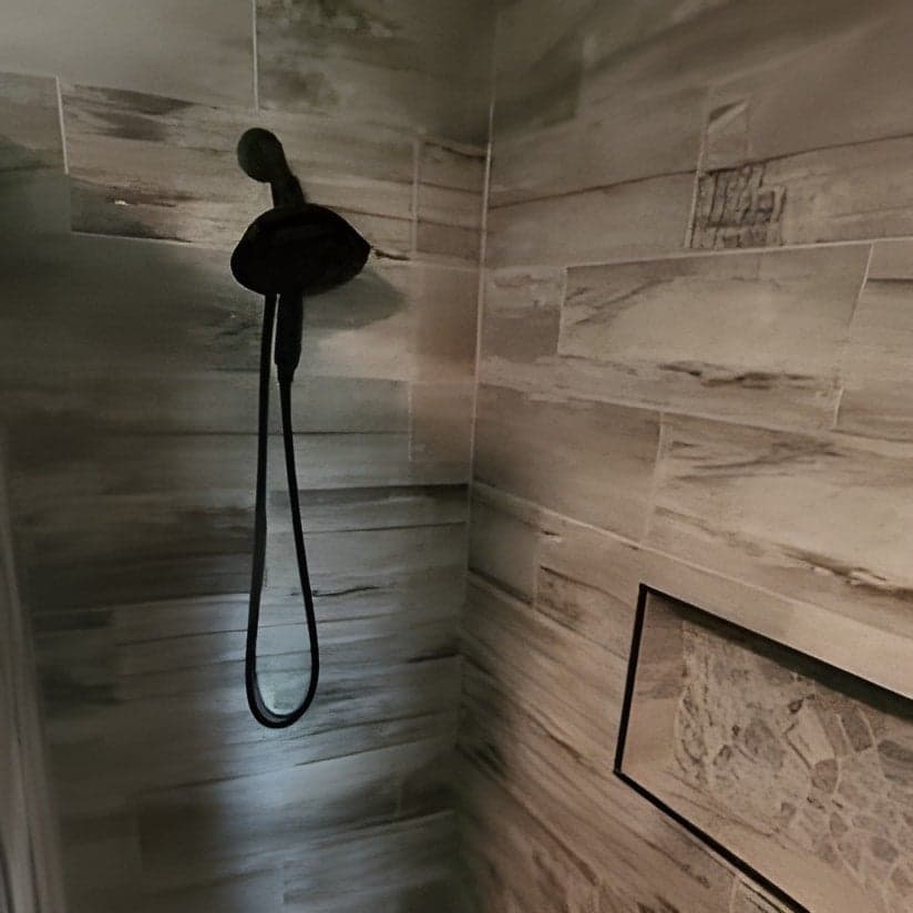 Finished shower enclosure with tile walls and black fixtures