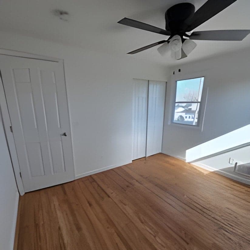 Finished bedroom with hardwood floors and ceiling fan