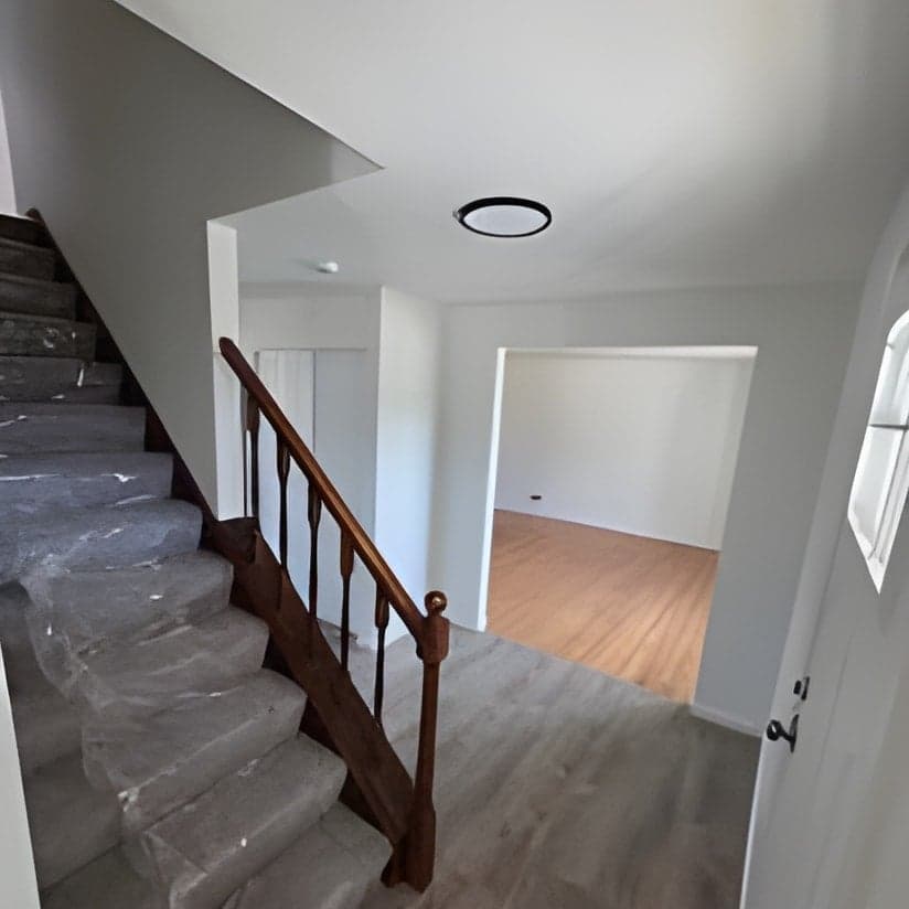 Finished staircase and entry hallway with wood railings