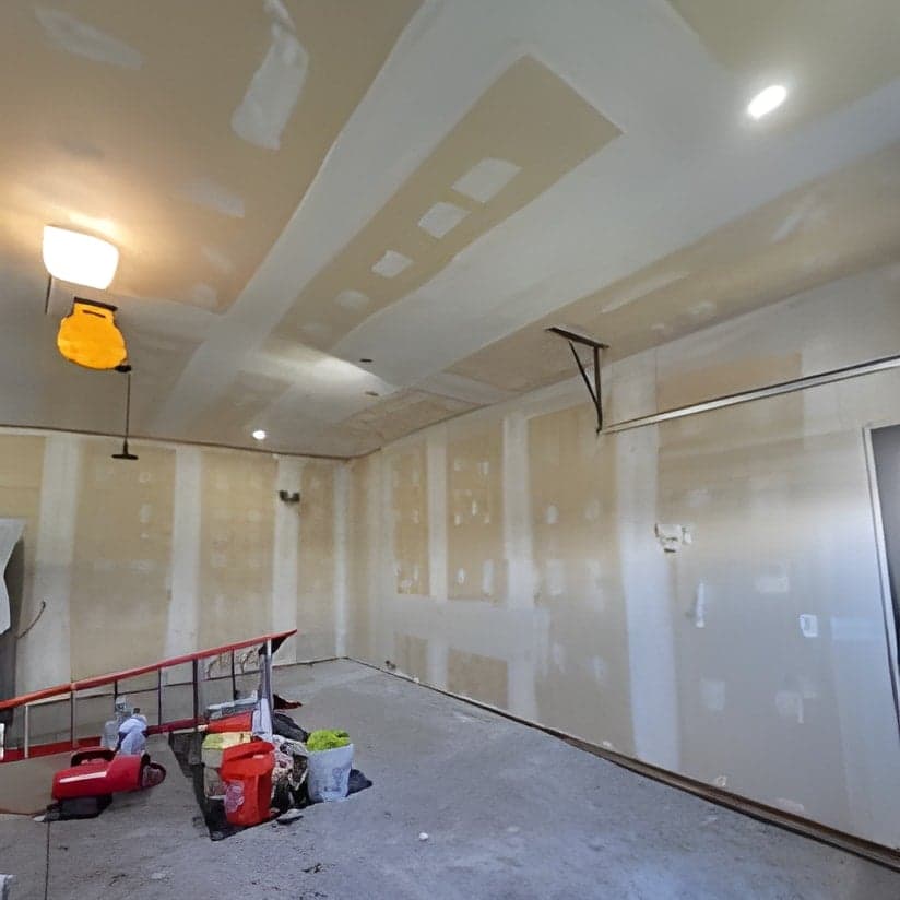 Drywall installation in progress, recessed lighting, open room