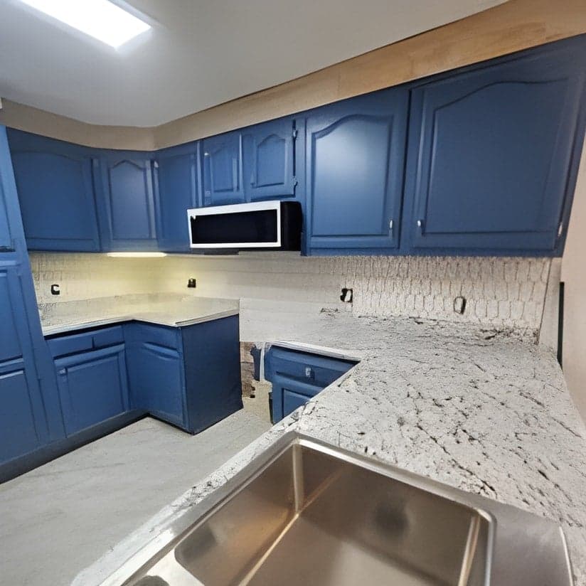 Finished blue kitchen with granite counters and stainless sink