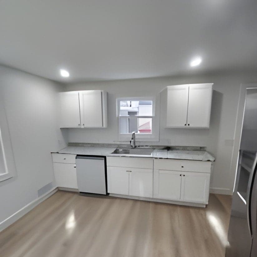 Modern kitchen with white cabinetry and wood flooring