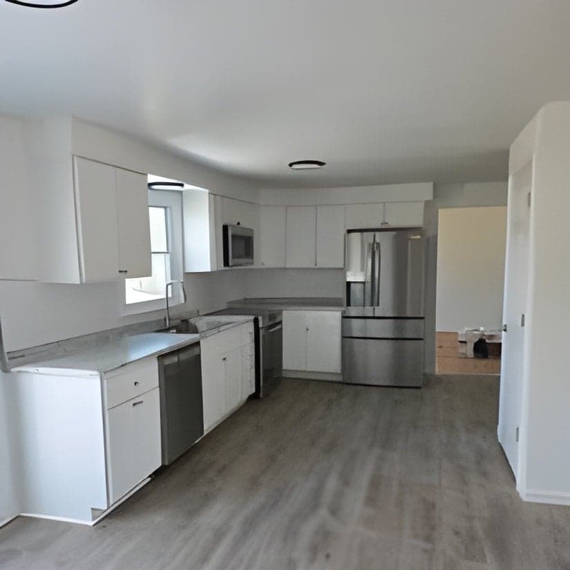 Finished kitchen with white cabinets and stainless appliances