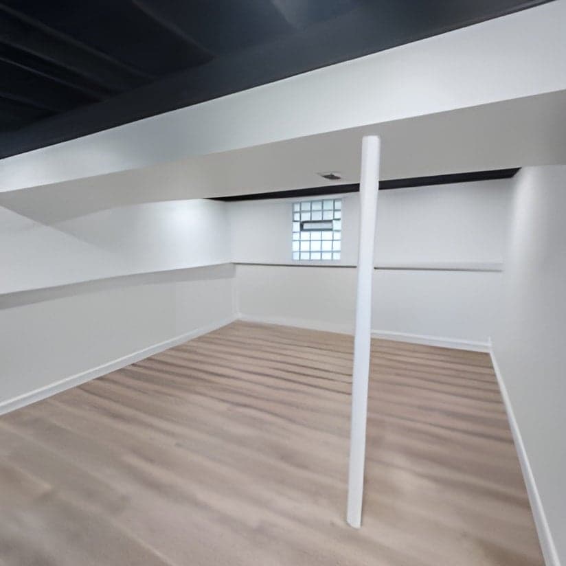 Finished basement with wood flooring and support column