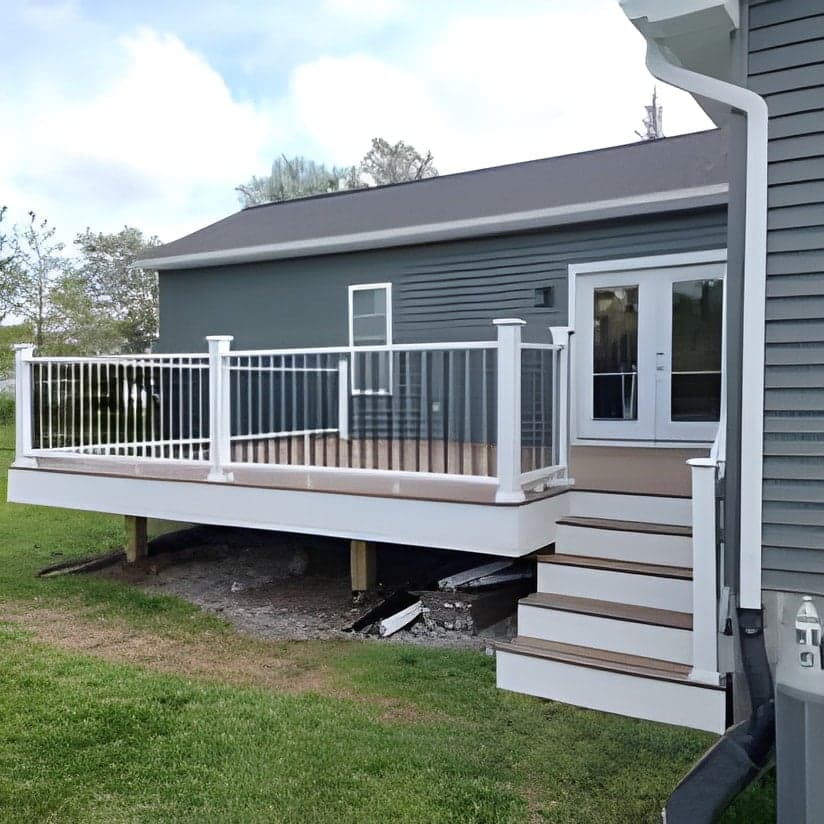 Finished white composite deck with railing attached to house